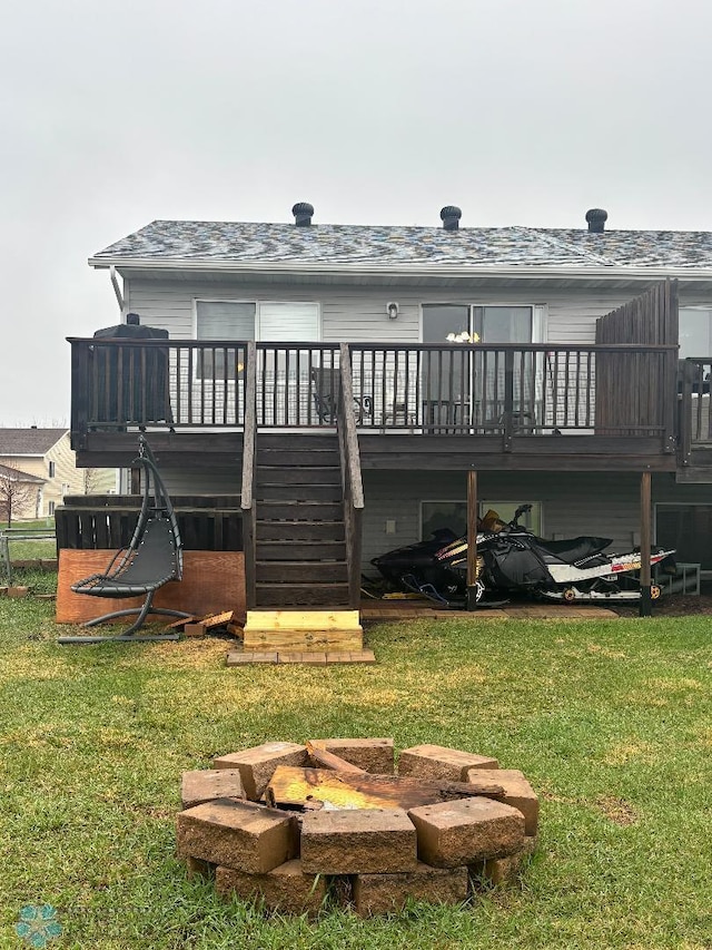 rear view of property with stairs, an outdoor fire pit, a lawn, and a wooden deck