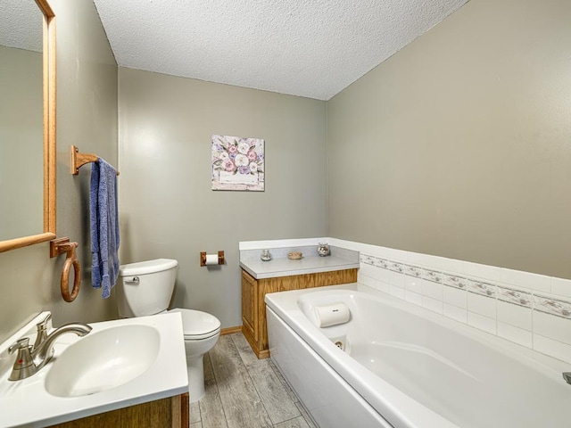 8918 Prestwick Pkwy N, Brooklyn Park, MN 55443 - bathroom featuring a whirlpool tub, a textured ceiling, wood finished floors, and vanity
