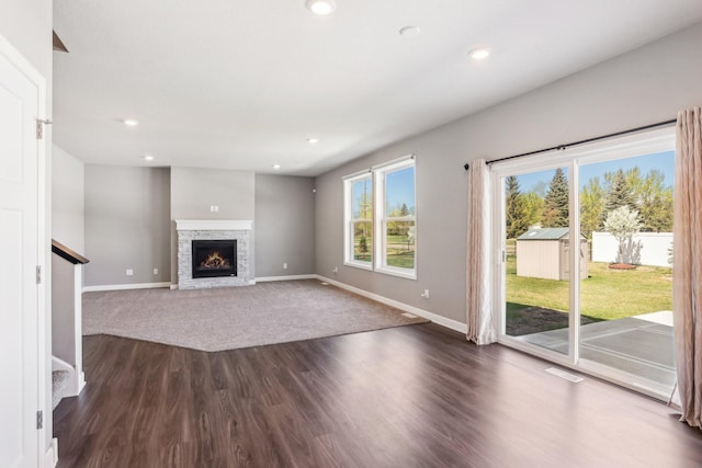 8441 152nd Ln NW, Ramsey, MN 55303 - unfurnished living room with baseboards, recessed lighting, dark wood finished floors, a stone fireplace, and stairs