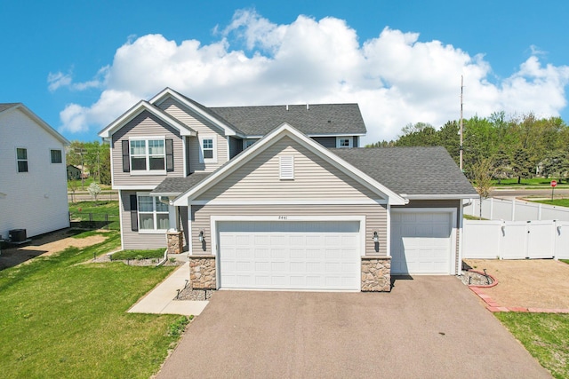 8441 152nd Ln NW, Ramsey, MN 55303 - view of front facade with driveway, an attached garage, stone siding, a shingled roof, and central AC unit
