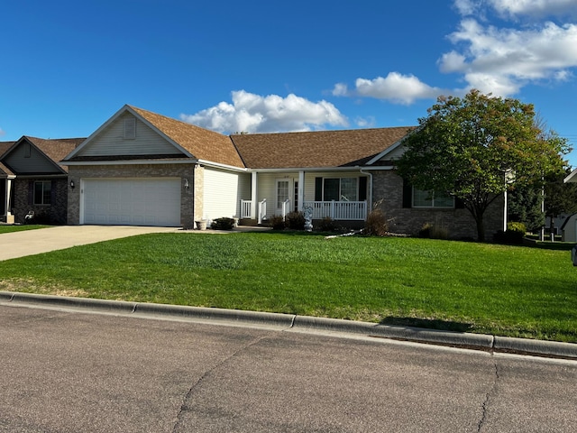 single story home featuring a garage, covered porch, a front yard, brick siding, and concrete driveway