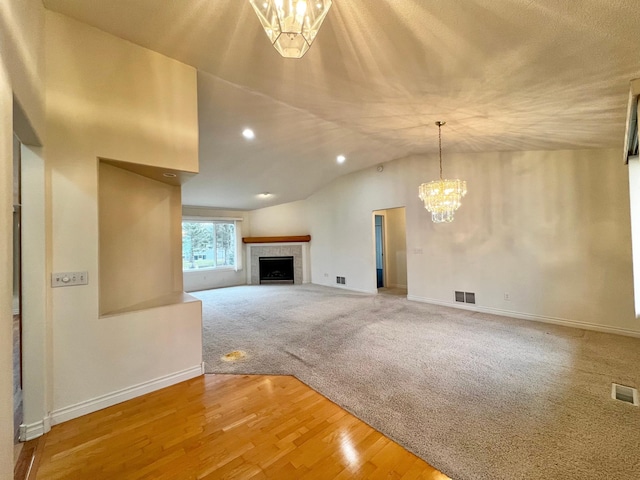 unfurnished living room with visible vents, baseboards, a chandelier, and a fireplace