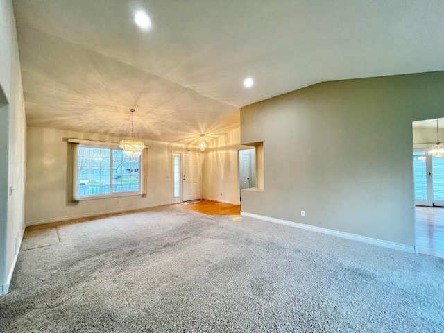 spare room featuring a notable chandelier, light carpet, recessed lighting, baseboards, and vaulted ceiling