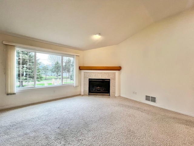 unfurnished living room featuring visible vents, a fireplace, vaulted ceiling, baseboards, and carpet