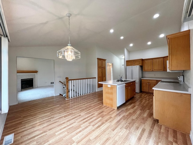 kitchen featuring a sink, white appliances, light countertops, open floor plan, and visible vents