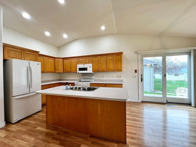 kitchen with vaulted ceiling, brown cabinets, wood finished floors, light countertops, and white appliances