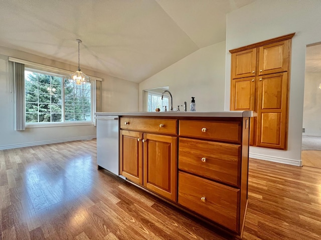 kitchen featuring wood finished floors, brown cabinetry, lofted ceiling, and dishwasher