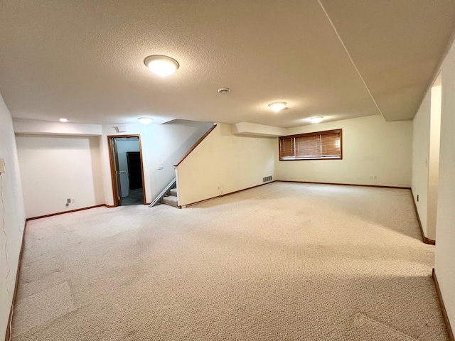 finished basement with visible vents, baseboards, and light carpet