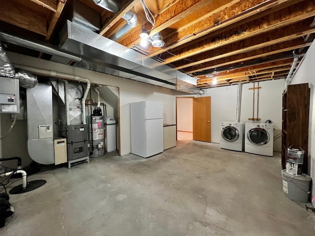 unfinished basement featuring heating unit, gas water heater, freestanding refrigerator, and washing machine and clothes dryer