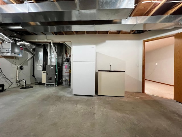 unfinished below grade area featuring freestanding refrigerator, heating unit, gas water heater, and refrigerator