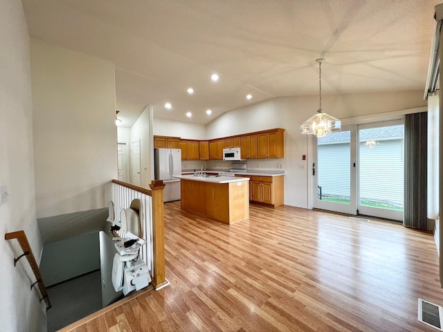 1647 8th Ave, Granite Falls, MN 56241 - kitchen featuring light wood-style floors, white appliances, a kitchen island with sink, light countertops, and visible vents