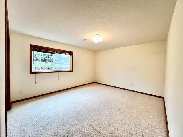 1647 8th Ave, Granite Falls, MN 56241 - spare room with light colored carpet, a textured ceiling, and baseboards