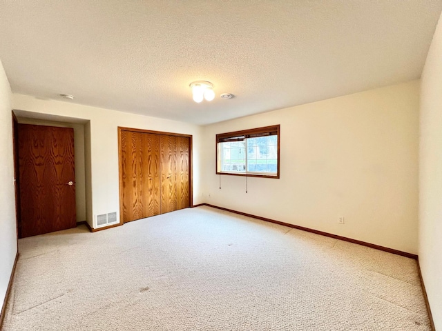 1647 8th Ave, Granite Falls, MN 56241 - unfurnished bedroom with baseboards, carpet, a closet, and visible vents