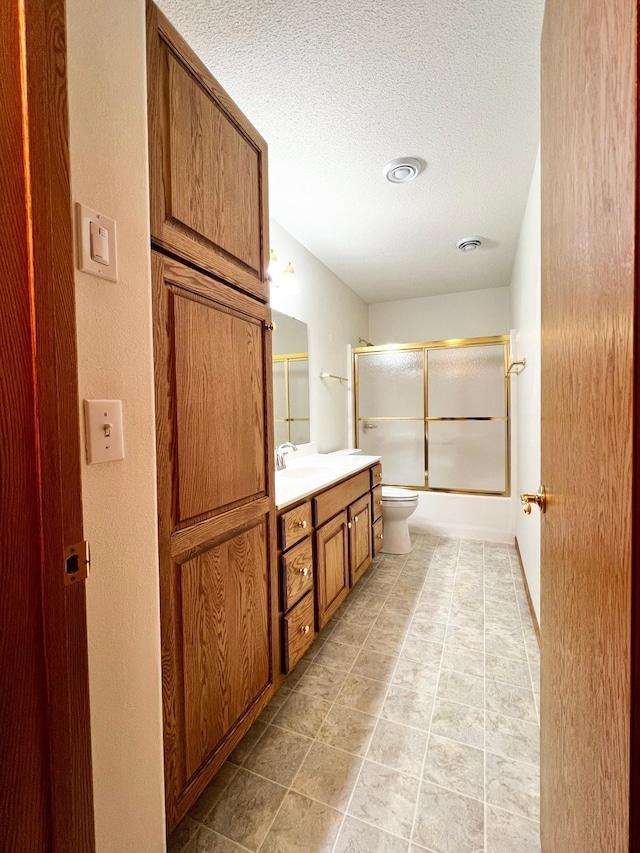 1647 8th Ave, Granite Falls, MN 56241 - full bath with vanity, toilet, bath / shower combo with glass door, a textured ceiling, and tile patterned floors