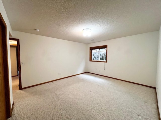 1647 8th Ave, Granite Falls, MN 56241 - empty room with baseboards, a textured ceiling, and light colored carpet