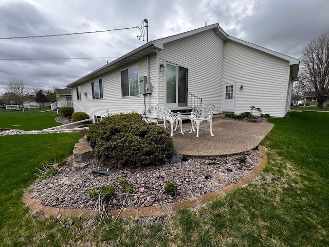 1647 8th Ave, Granite Falls, MN 56241 - rear view of house featuring a lawn and a patio area