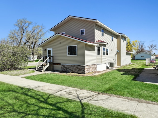 view of side of property featuring central air condition unit and a lawn