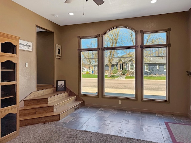 entryway featuring a ceiling fan, baseboards, recessed lighting, and stone tile flooring