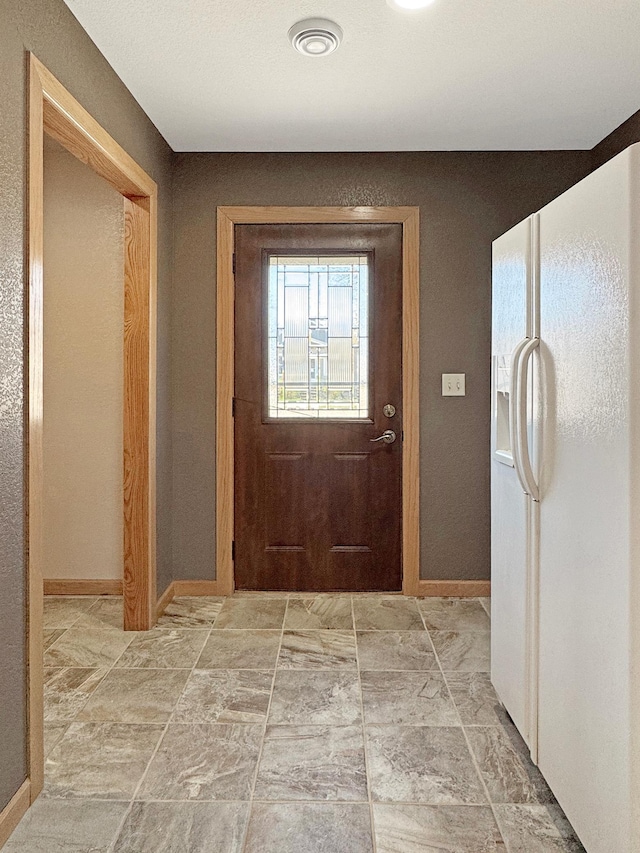 doorway to outside with baseboards and visible vents