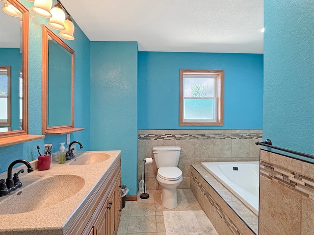 bathroom with double vanity, toilet, a sink, and a garden tub