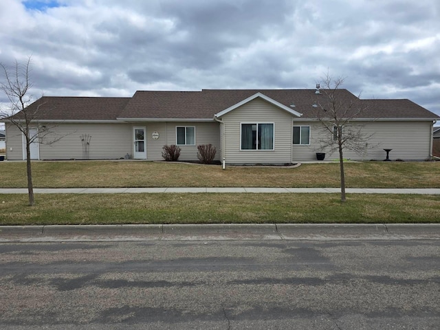 single story home featuring roof with shingles and a front yard