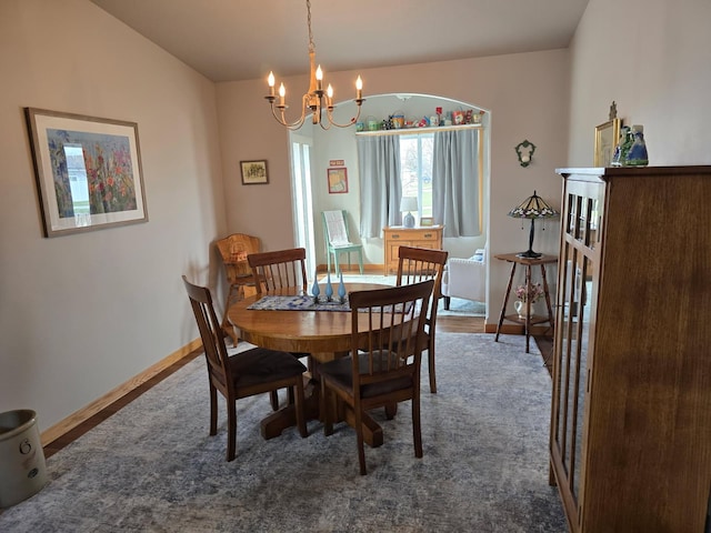 dining space with baseboards, carpet flooring, and an inviting chandelier