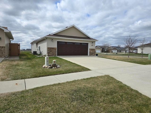 view of front of property with concrete driveway, an attached garage, a front lawn, and stone siding