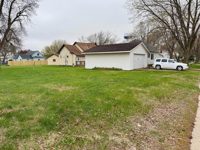 view of yard with fence and a detached garage