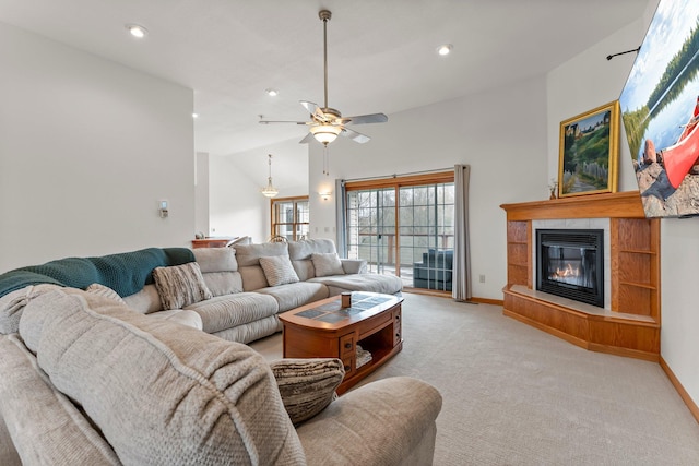 living room featuring ceiling fan, light colored carpet, a glass covered fireplace, baseboards, and lofted ceiling