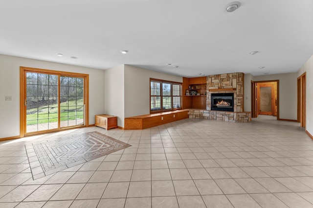 unfurnished living room with recessed lighting, baseboards, light tile patterned floors, and a fireplace
