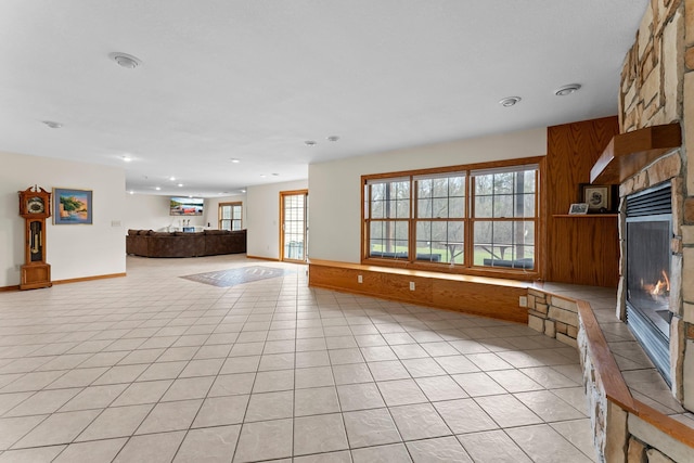 unfurnished living room with recessed lighting, light tile patterned flooring, and a fireplace