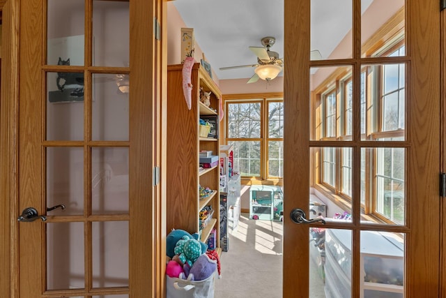 doorway with french doors, a ceiling fan, and carpet