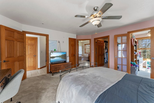 bedroom featuring light colored carpet, a walk in closet, french doors, ensuite bathroom, and a closet