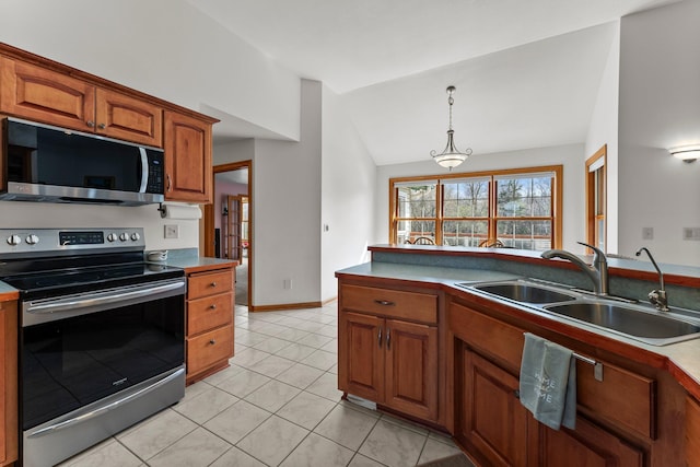 kitchen with brown cabinetry, a sink, appliances with stainless steel finishes, light tile patterned floors, and vaulted ceiling
