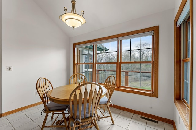 dining area with light tile patterned flooring, baseboards, visible vents, and lofted ceiling