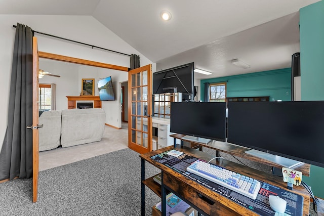 office space featuring a healthy amount of sunlight, french doors, carpet flooring, and lofted ceiling