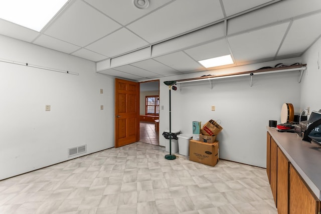 below grade area featuring light floors, a paneled ceiling, and visible vents