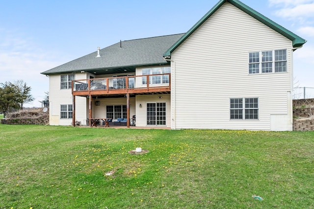back of property with a lawn, a shingled roof, a patio area, and a deck