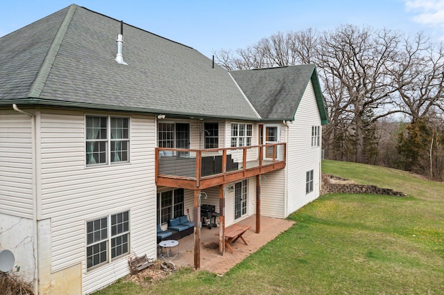 back of property featuring a lawn, a patio, and roof with shingles