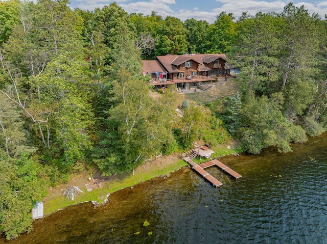 birds eye view of property featuring a water view and a wooded view