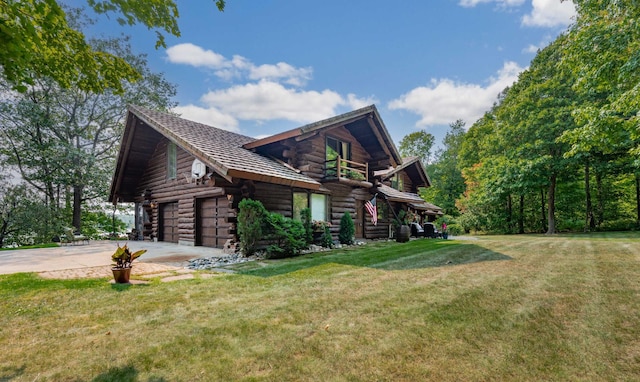 view of side of property featuring a lawn, driveway, and log exterior