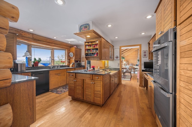 kitchen with brown cabinetry, dark countertops, a sink, double oven, and black dishwasher