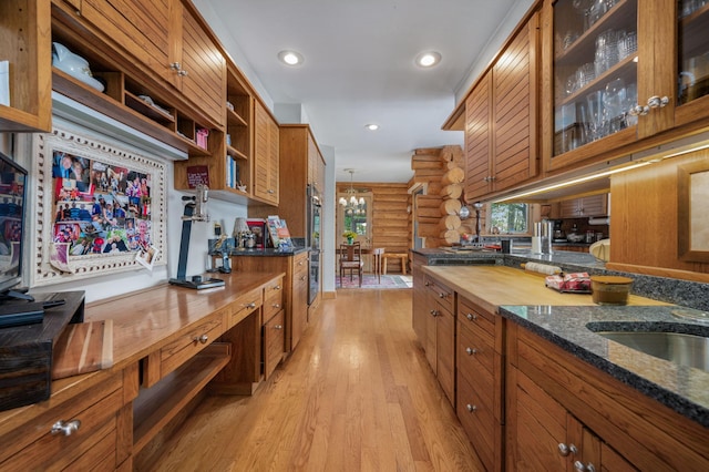 kitchen with brown cabinets, open shelves, light wood finished floors, wooden counters, and rustic walls