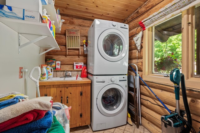 clothes washing area featuring a sink, wood ceiling, laundry area, and stacked washer / dryer