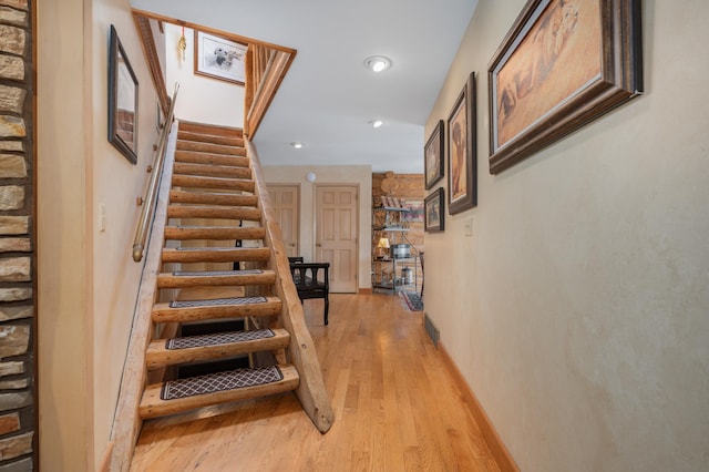 staircase with recessed lighting, baseboards, and wood finished floors