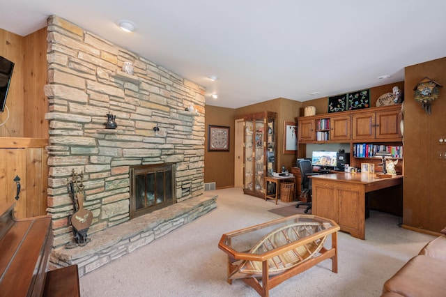 office area featuring visible vents, light colored carpet, built in study area, and a fireplace
