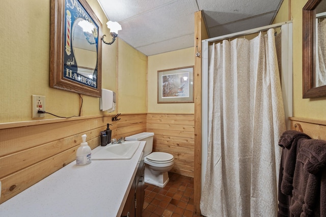 full bath with a shower with curtain, wood walls, a wainscoted wall, vanity, and toilet