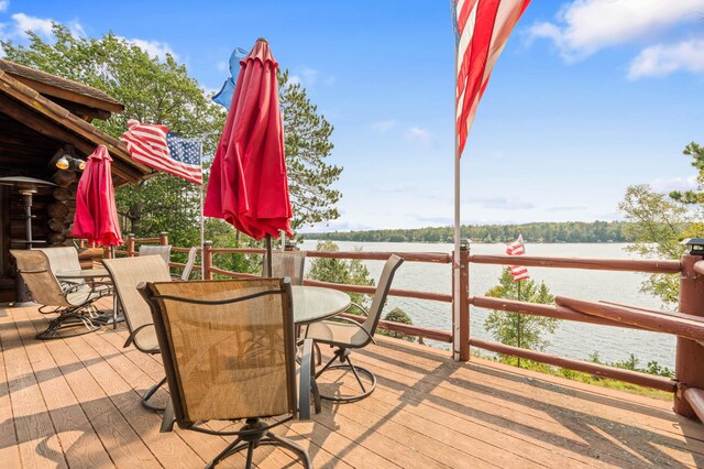 deck featuring a water view and outdoor dining space