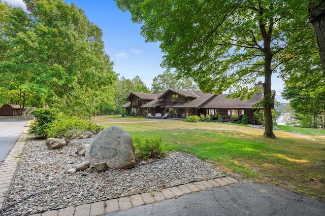 view of front facade with log exterior and a front yard