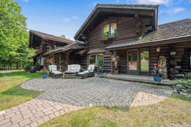 back of property featuring an outdoor living space, a yard, a patio, and log siding